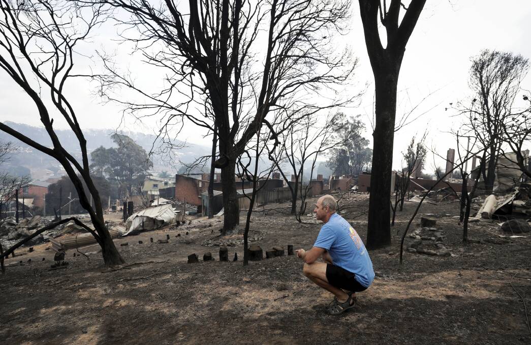 CATHARSIS: Tathra resident John Plumb surveys what was left of his neighbourhood following the March 18 bushfire. He was one of many who stayed behind to fight. Picture: Alex Ellinghausen