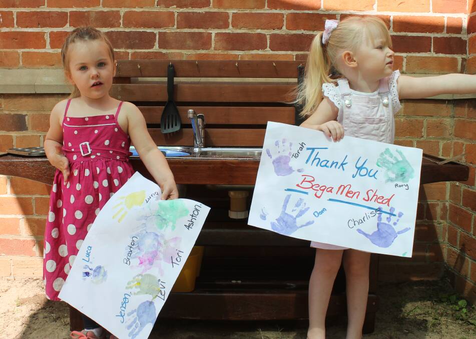 Luna Otton and Charlise Grew thank the Bega Men's Shed for their new play kithcen. Picture: Albert McKnight.
