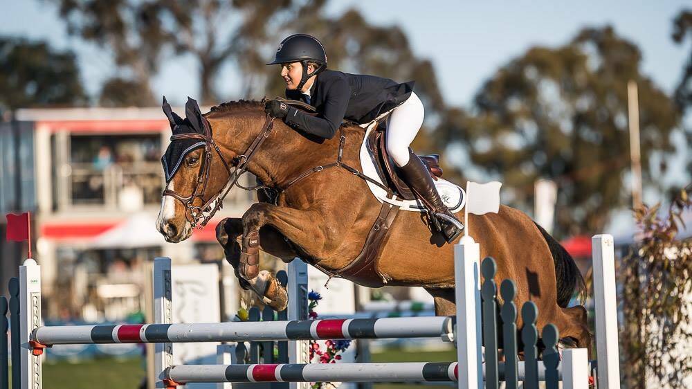 COMBINATION: Jamie Priestley and her horse Optimus compete at the recent Australian show jumping championships. Photo: STEPHEN MOWBRAY