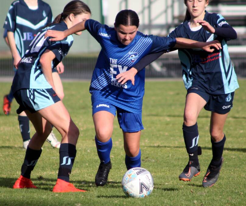 Southern Branch under 14s player Isabelle Harris splits two Sutherland defenders on Sunday. Photo: Freddie Simon