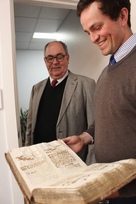 Looking at history: Hugo White and son Oliver White of Sautelle White Lawyers with an old book of hand written letters from the 1800s.