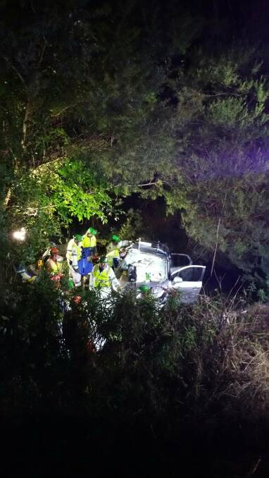 Emergency crews work together to free a woman trapped in an overturned vehicle at Kianga, north of Narooma on Thursday, June 6. Picture: NSW Fire and Rescue.