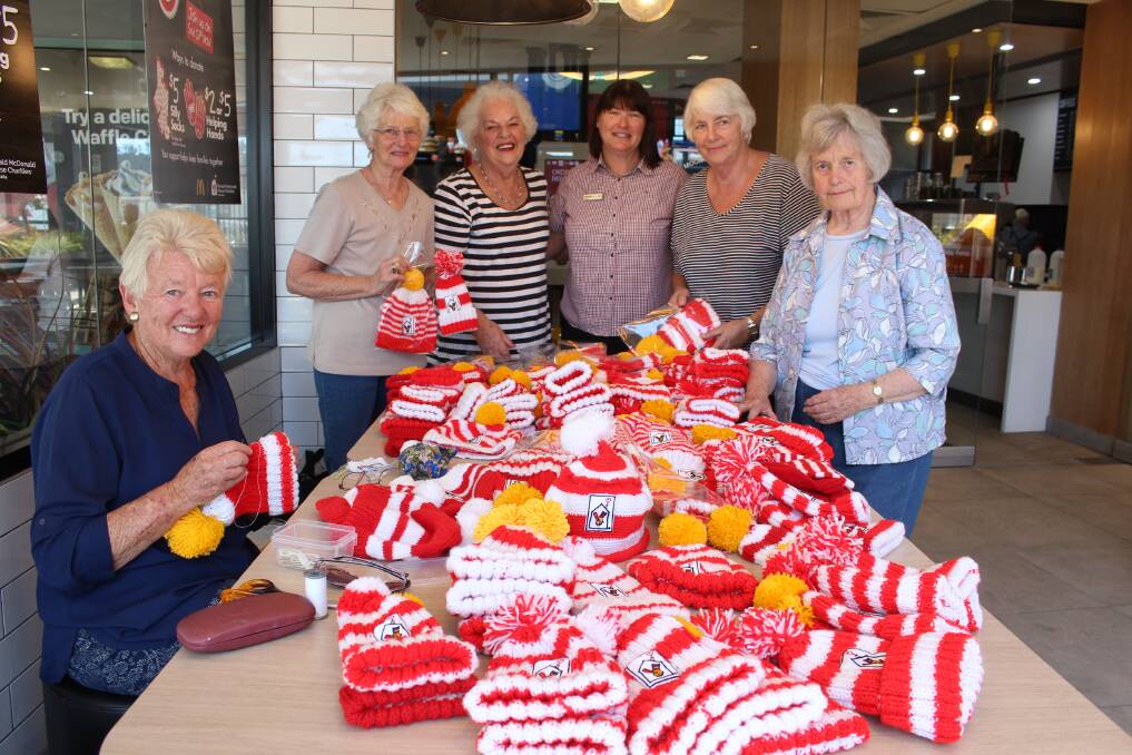 charity: Pambula Merimbula CWA ladies and Penny Malone (centre) packing each hand-knitted beanie ready to sell at the McHappy Day preview this Saturday. 