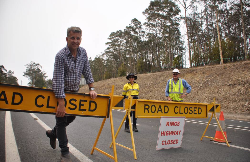 HAPPY CHAPPIE: Bega MP Andrew Constance removes the roadblock on the Kings Highway on Tuesday afternoon, watched by Robyn Lyster and Stephen Edwards.