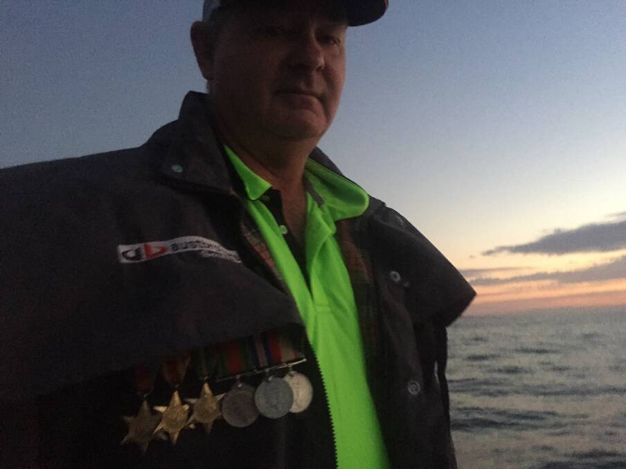Rob Pollock wears his grandfathers war medals at the Tuross Head Dawn Service 2019. 