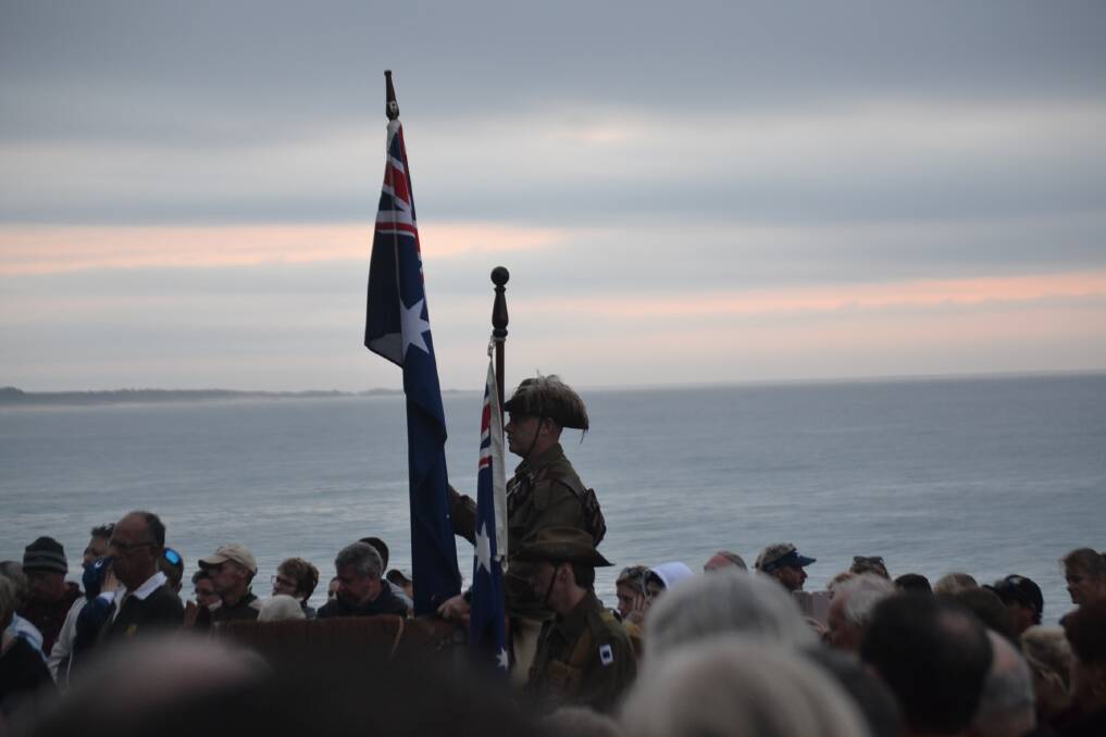 The rising sun cuts through the cloud at Tuross Head on April 25, 2019, for the Anzac Day dawn service.
