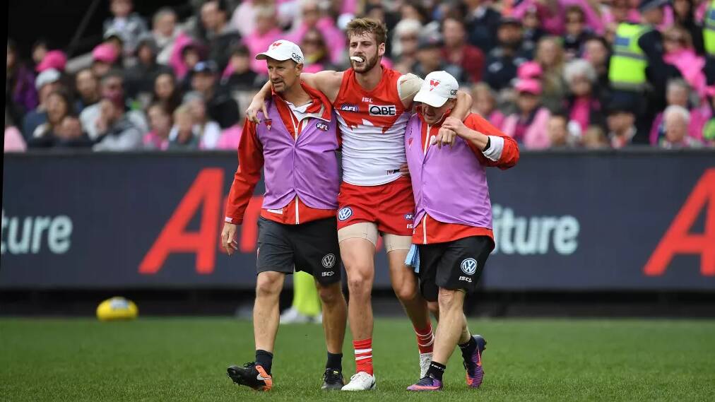 Agony: Alex Johnson is helped off the field with an ACL injury. Photo: AAP