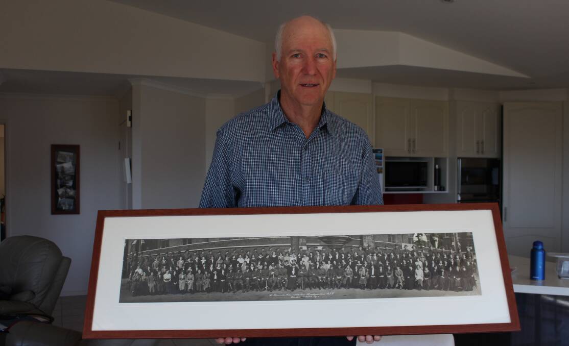 John Dedman holds a photo of all those working in the Australian Records "B" Section in London including his grandfather and his grandfather's wife (also shown in inset photos).