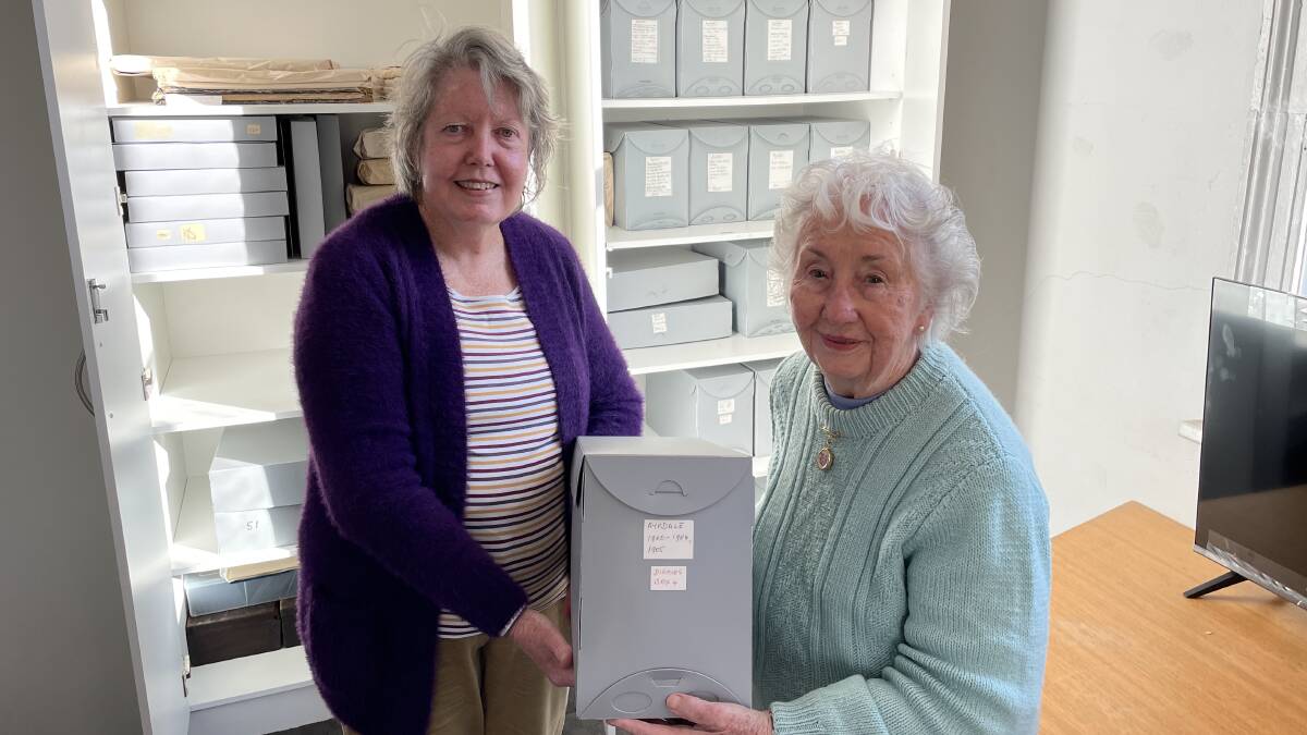Bega Valley Genealogy Society treasuer Joan Brown and librarian Ursula Hunt with one of the new archive boxes that fit in custom-made cabinets.