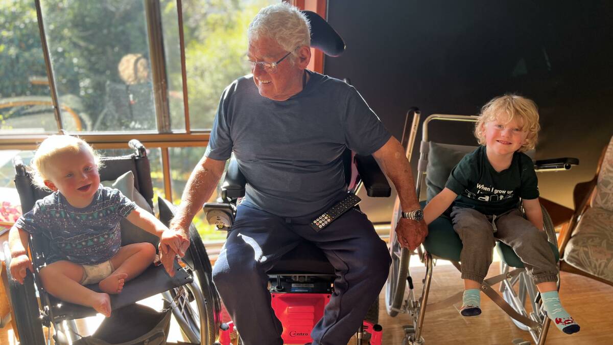 Ron Finneran with two of his grandchildren, showing them wheelchairs. Picture supplied