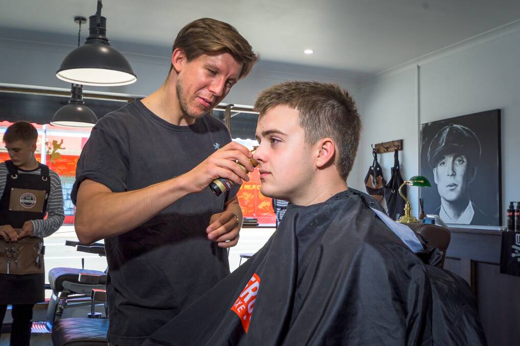 New Look: Traditional Devonport barber Daniel Logue. owner of Daniel and the Lion's Den, cuts his client Quinn Turner's fade mullet in the making. Picture: Simon Sturzaker. 