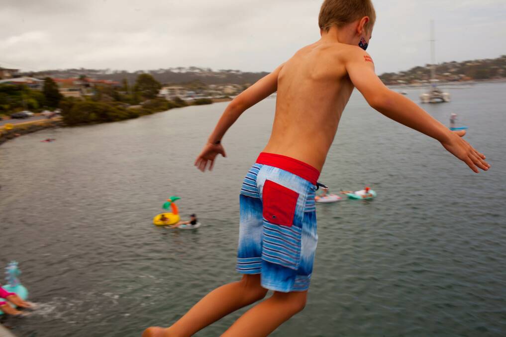 Taking the plunge: A boy jumps off the Merimbula bridge into the lake at high tide on Australia Day. Photo: Rachel Mounsey