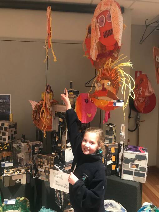 Junk Paradise: Merimbula Public pupil Maeve Kennedy shows off her art featured as part of the buddy project artwork created by Merimbual Public School pupils in years 3 and 5. Photo: Michelle Hulme