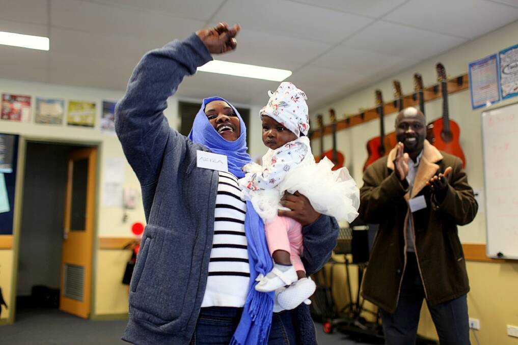Mohammed claps as Aziza and her daughter Sajda dance to a protest anthem in front of a packed classroom at Lumen Christi School during a refugee visit to the Far South Coast. Photo: Rachel Mounsey