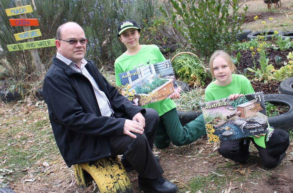 EXCITING HOBBY: Bega Post Office postal manager Peter Truscott talks about collecting stamps with Sapphire Coast Anglican College pupils Nate Wood and Sian Malseed. 