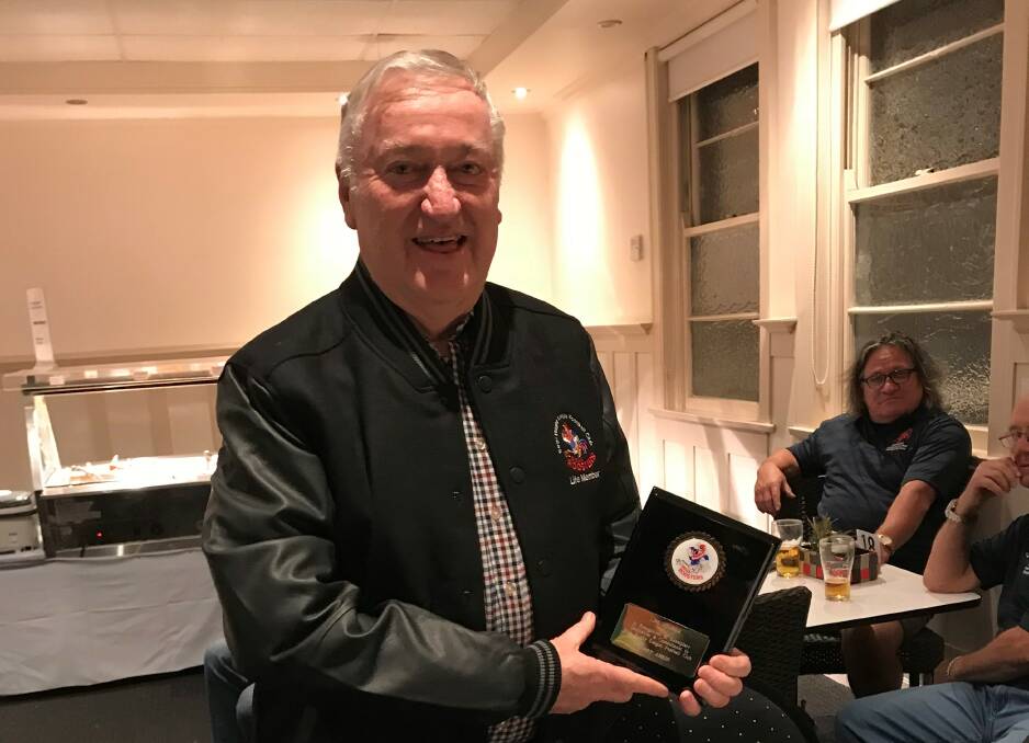 Garry Arkin holds his life membership award, presented at a 30-year reunion for the Bega Roosters. 
