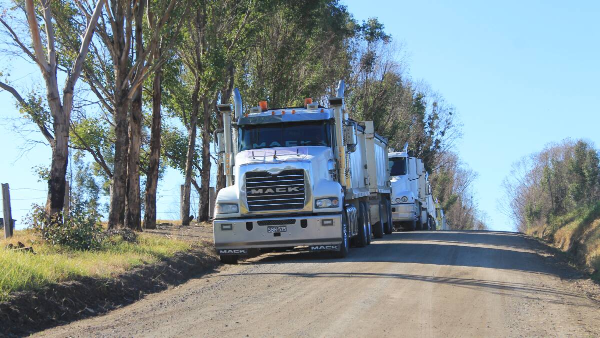 Eight trucks were parked along Coolagolite Rd on Monday for the bushfire clean-up on nearby properties. 