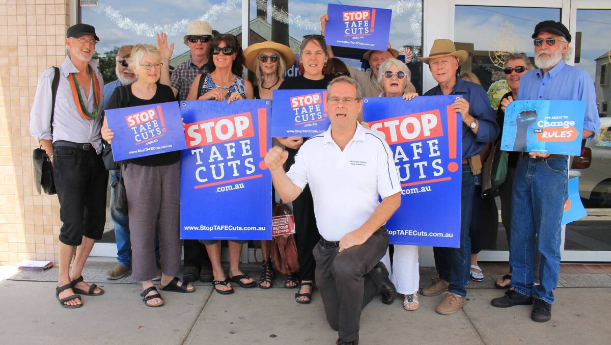 NSW Teachers Federation organiser Rob Long leads a chant with members of the community outside Member for Bega Andrew Constance's office in Bega on December 12. 