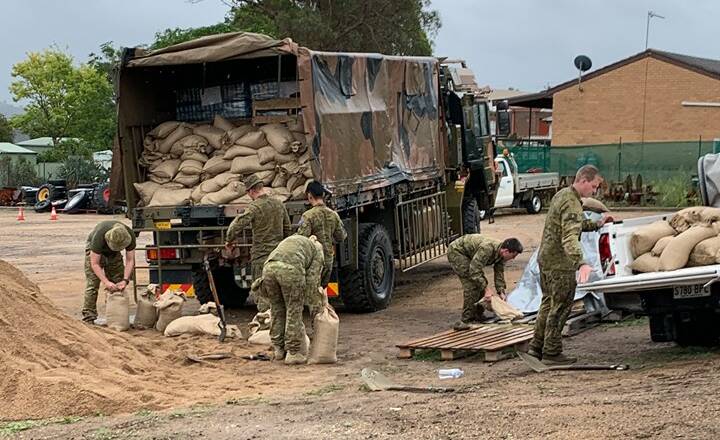 Australian Defence Force personnel give SES workers a hand filling sandbags. Picture: Bega Valley SES/Facebook 