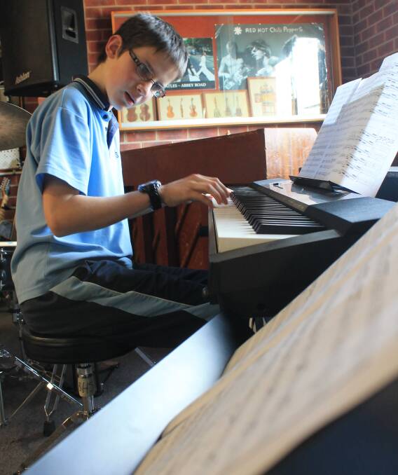 MUSICAL GENIUS: Bega High School's Year 8 student Oscar Gill performs a piece on piano while playing in his school's music rooms. Picture: Albert McKnight