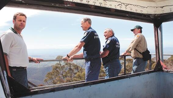 Dean Payne, John Cullen, Brian Ayliffe and Peter Windle take in the view from Wolumla Peak in 2009. The missing glass is the result of the fourth spate of vandalism over 18 months, which was reported at the time. 