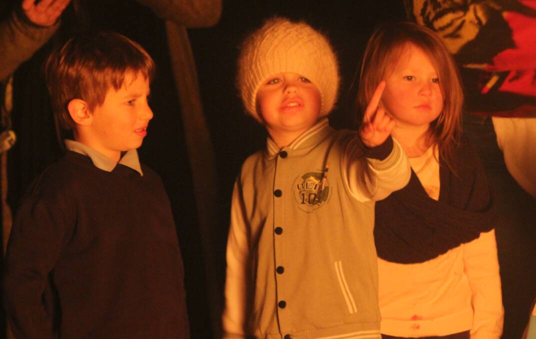 CELEBRATING COMMUNITY: Charlie, Cooper and Quinn of Bermagui Preschool gather around the bonfire on Friday night. 
