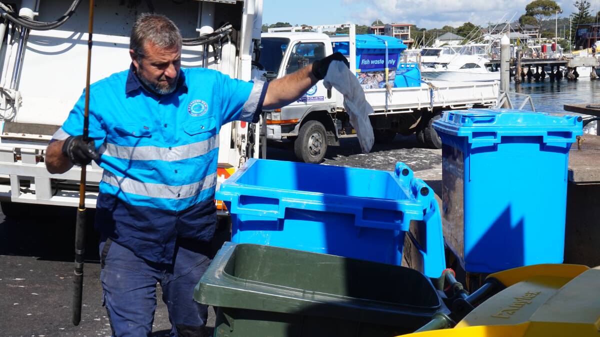 Ocean2earth co-founder Tim Crane pulls plastic out of the fish waste bins at Bermagui's harbour at his company's launch in April. 