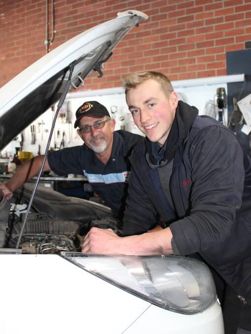 TEAMWORK: Anthony's Car and Head Centre owner Anthony Dack and apprentice Jayden Barnes work on a vehicle together. 