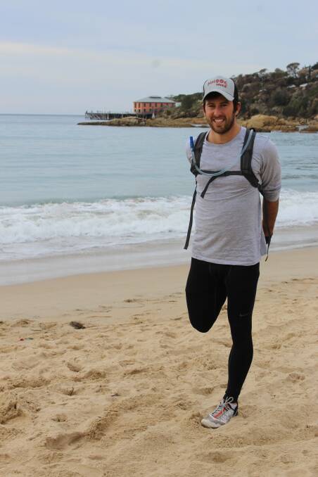 WARM UP: James McAlloon stretches on Tathra Beach ahead of his 217km run from the beach to Mount Kosciuszko. 