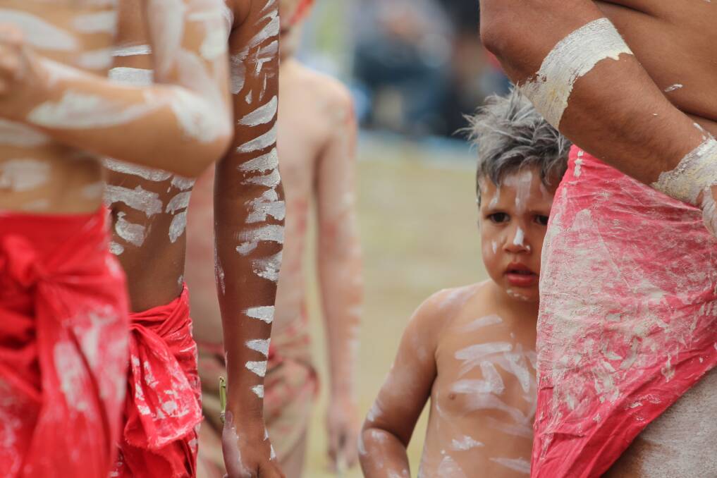 A child waits for the dance to start at the historic event on Yuin land at Gulaga on Sunday, December 1. Picture: Albert McKnight 