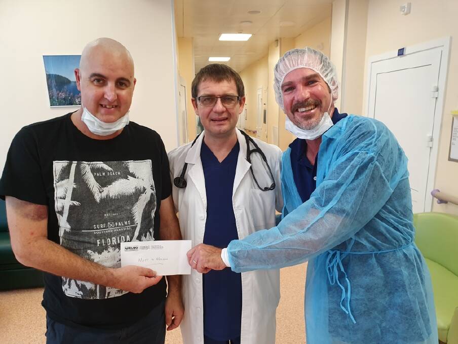 SUCCESS: AutoPro Bega's Steve Parker (right) hands Matthew Taylor a cheque for $2300 at a hospital in Moscow as a result of in-store fundraising efforts while Dr Denis Fedorenko looks on.