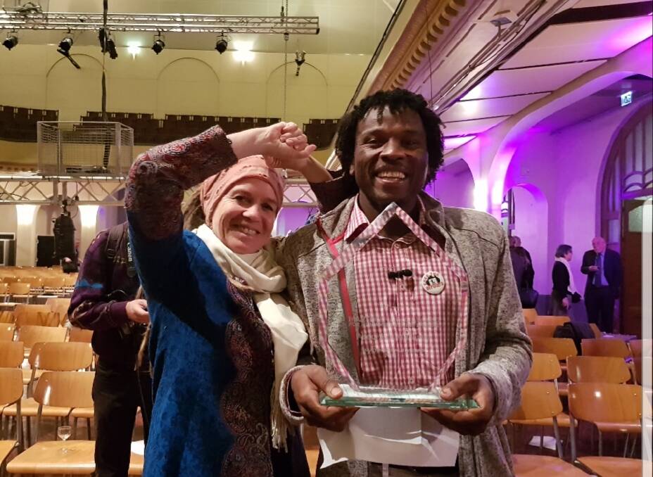 A HAPPY MOMENT: Eve Hofstetter smiles for the camera with Abdul Aziz Muhamat, a refugee who was detained on Manus Island before being granted asylum in Switzerland, when he won the Martin Ennals Award in Geneva in February. Picture: Supplied 
