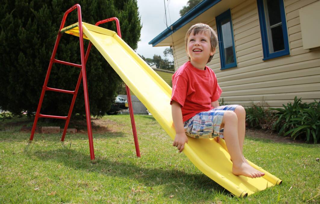 FAVOURITE TOY: Jesse Buchli of Bermagui was all smiles when playing on his new yellow and red slippery dip. By Wednesday he had already gone down it 100 times. Picture: Albert McKnight