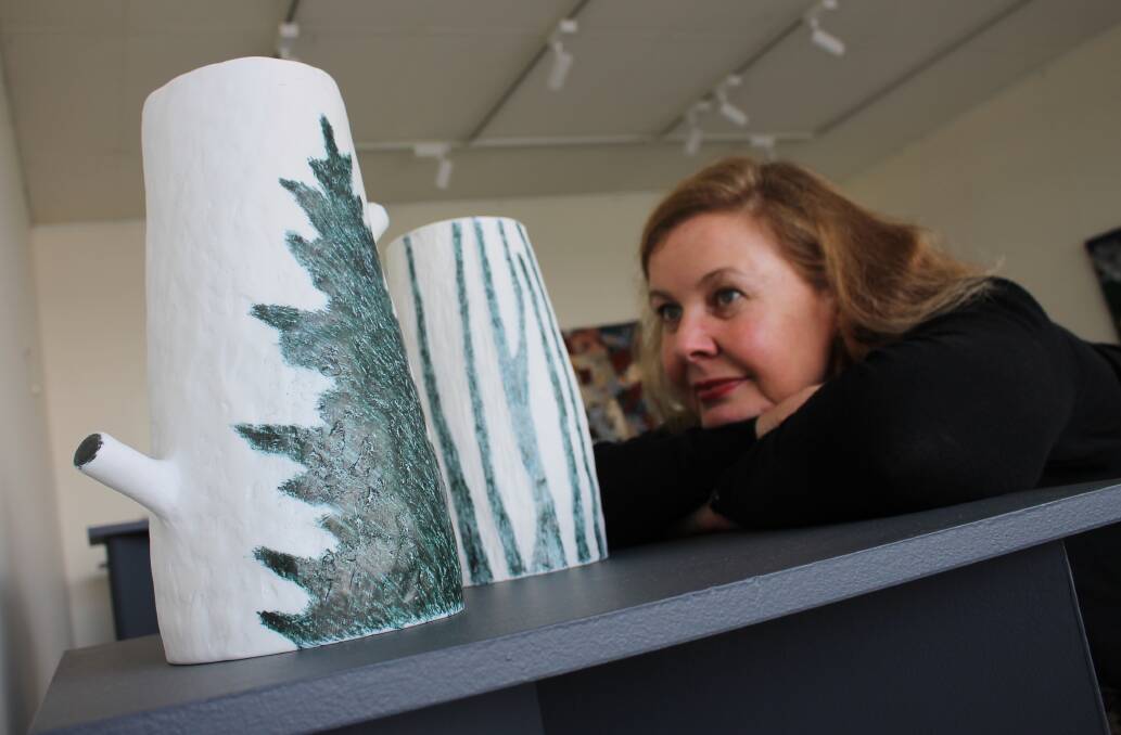 WORLD OF ART: Melbourne ceramicist Janetta Kerr-Grant examines two of the artworks she is exhibiting at the Landscape exhibition. 