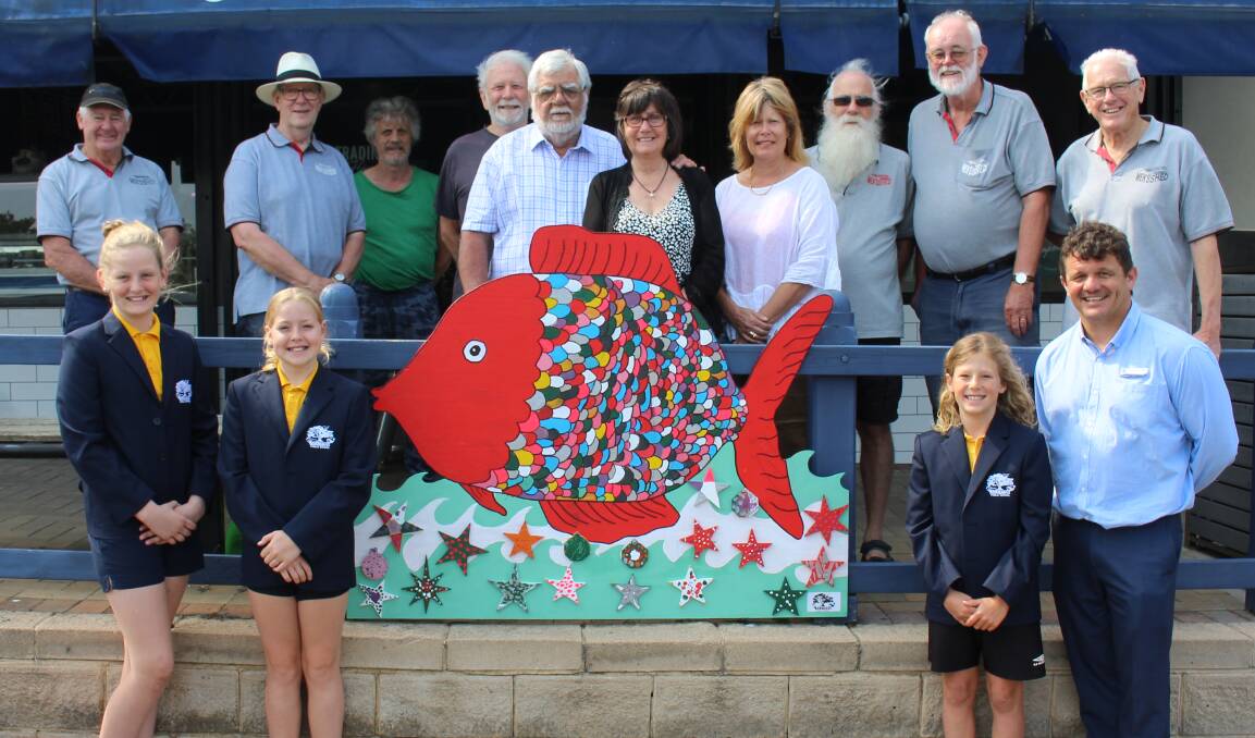 EYE-CATCHING: Members of the Bermagui Chamber of Commerce, Men's Shed and Public School visit the signs installed on the town's main street. 
