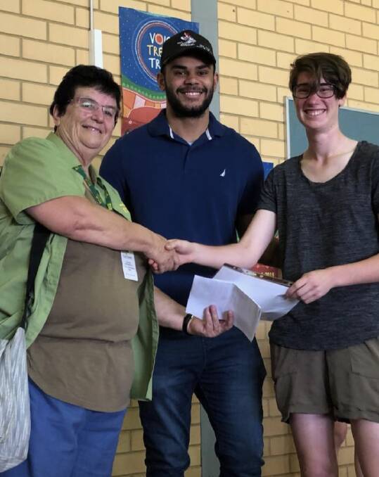 KIND HEARTS: Can Assist representative Brenda Montgomery receives the donation from outgoing Year 12 captains Darnell Andy and Janet King. 
