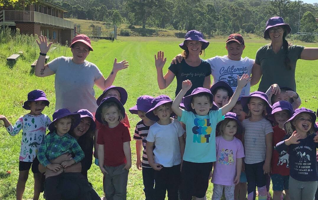 CHEERING HER ON: Sonia Evans (back, third right), staff, parents and children of the Cobargo Preschool celebrate after a run on Wednesday. 
