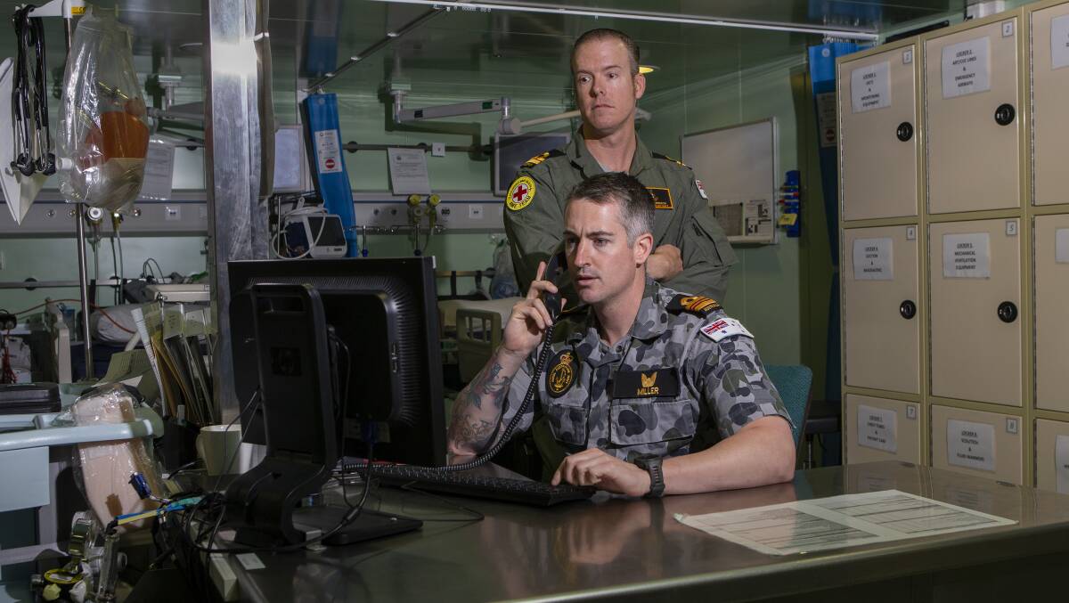HMAS Adelaide's embarked nursing officers, Lieutenant Commander Thomas Miller (front) and Lieutenant Travis Robinson in the treatment room during Operation Bushfire Assist 19-20. Picture: ABIS Thomas Sawtell
