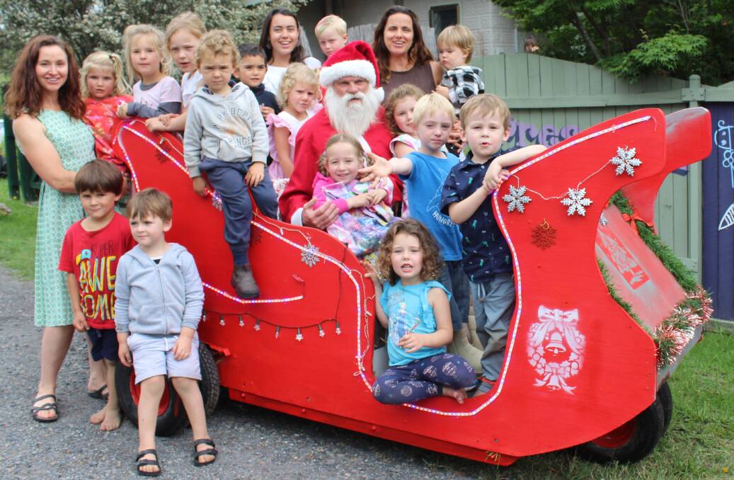 ALL ABOARD: Dave Rugendyke, AKA Santa, invites the children and staff of Cobargo Preschool to sit on the sleigh he built from a '60s golf cart. 