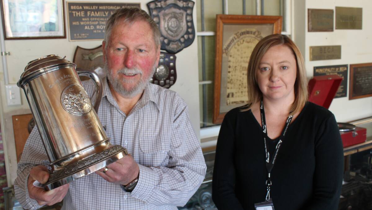 Peter Lacey holds a Candelo Athletic Club cup from 1888, watched on by council's Carley McGregor. 