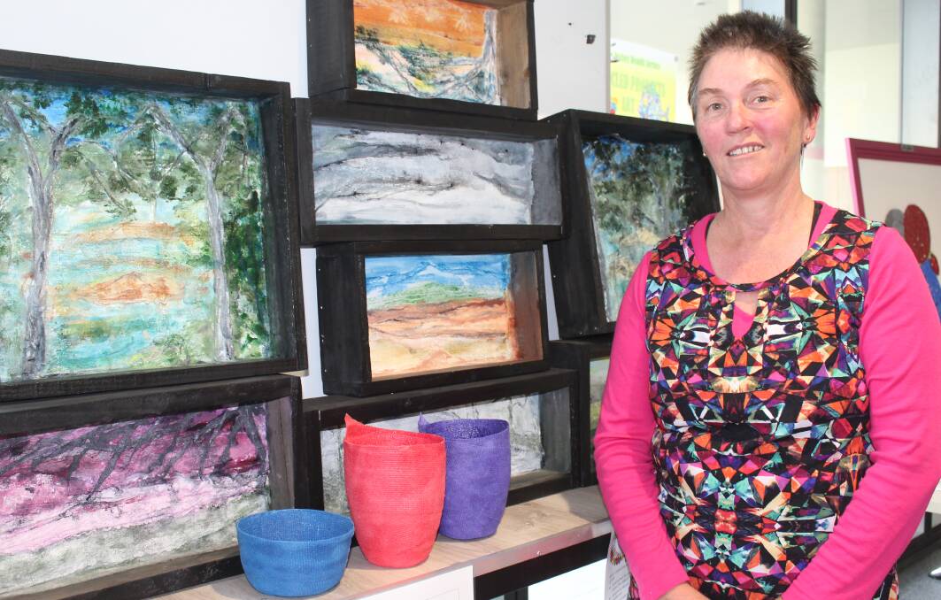 COLOURFUL CREATIONS: Tanya Pearce stands next to her artworks, coloured bowls and representations of the Bega Valley made from wooden pallets and out of date plaster. 