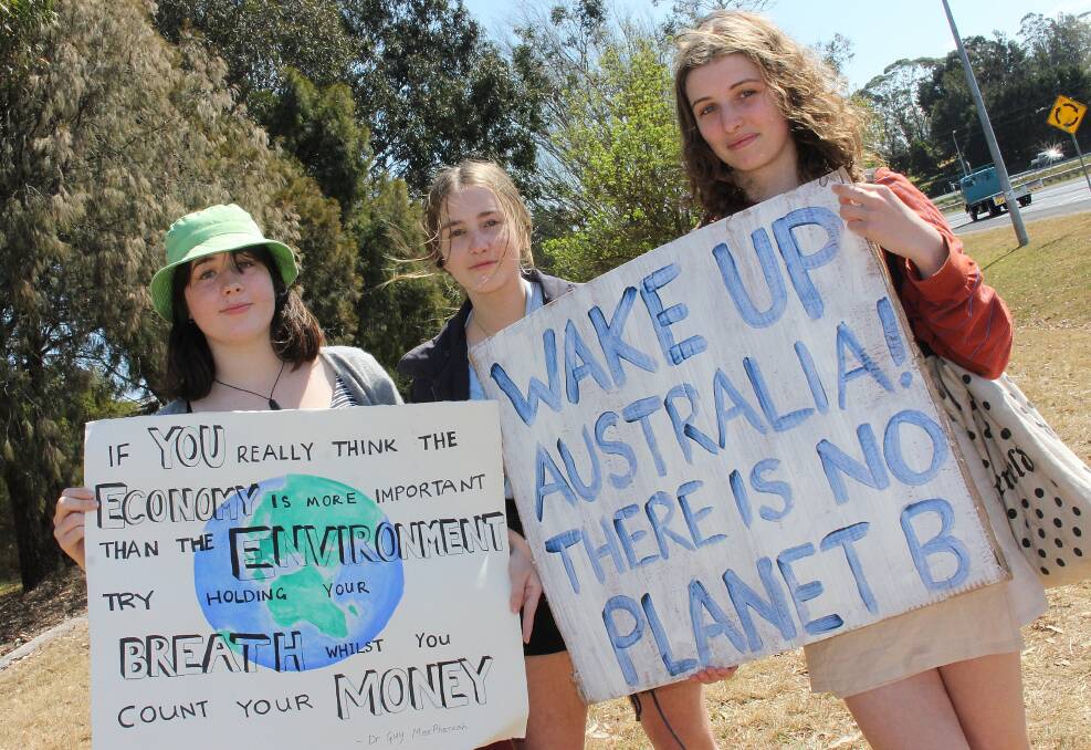 YOUTH ACTION: Genevieve Comer-Kleine of Buckajo, 16, Ella Burke of Candelo, 15, and Esme Barker of Bega, 16, prepare to walk from North Bega to Littleton Gardens for the climate strike. 