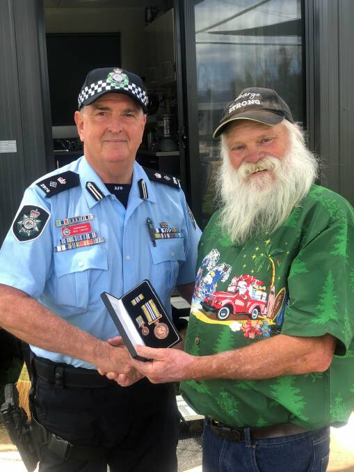 Dave Rugendyke (right) is presented with a replacement National Medal, AFP Service Medal and Certificate of Service on Wednesday. Picture: AFP 