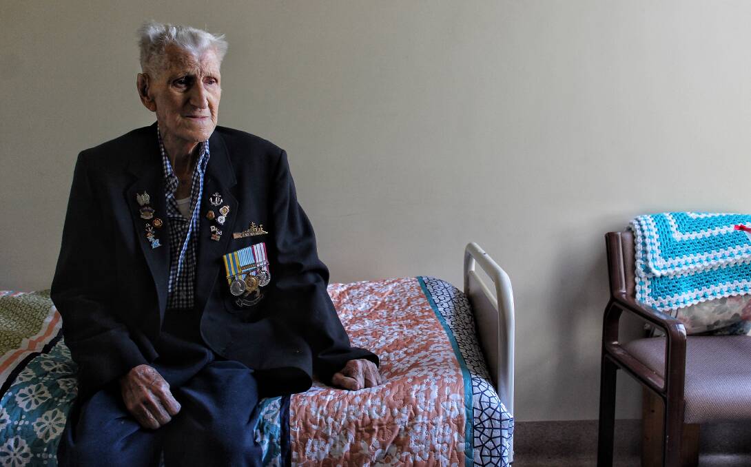VETERAN: Tom Blake dons the jacket covered in badges he will wear to Bega's Anzac Day march. Picture: Albert McKnight 