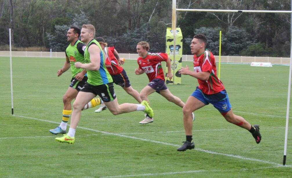 Burst of speed: Canberra Raiders test their pace against some quick young Bega players during a special training camp in Canberra on the weekend. 