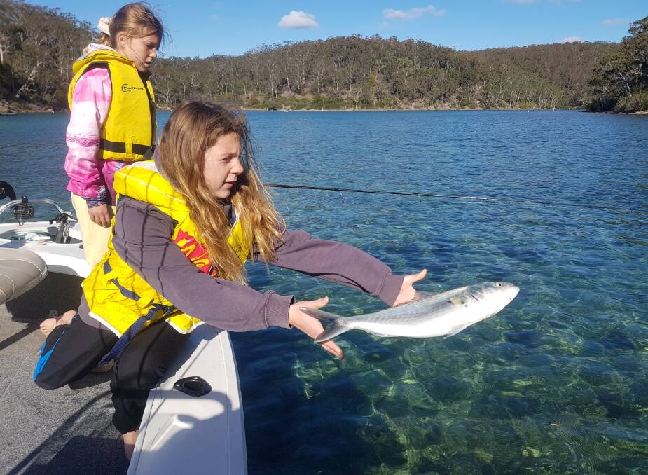 12 yr old Rali Badullovich with 10 yr old Ava Tatman on the Pambula River releases a fine Australian Salmon caught during the Winter Holiday Junior Fishing Competition 