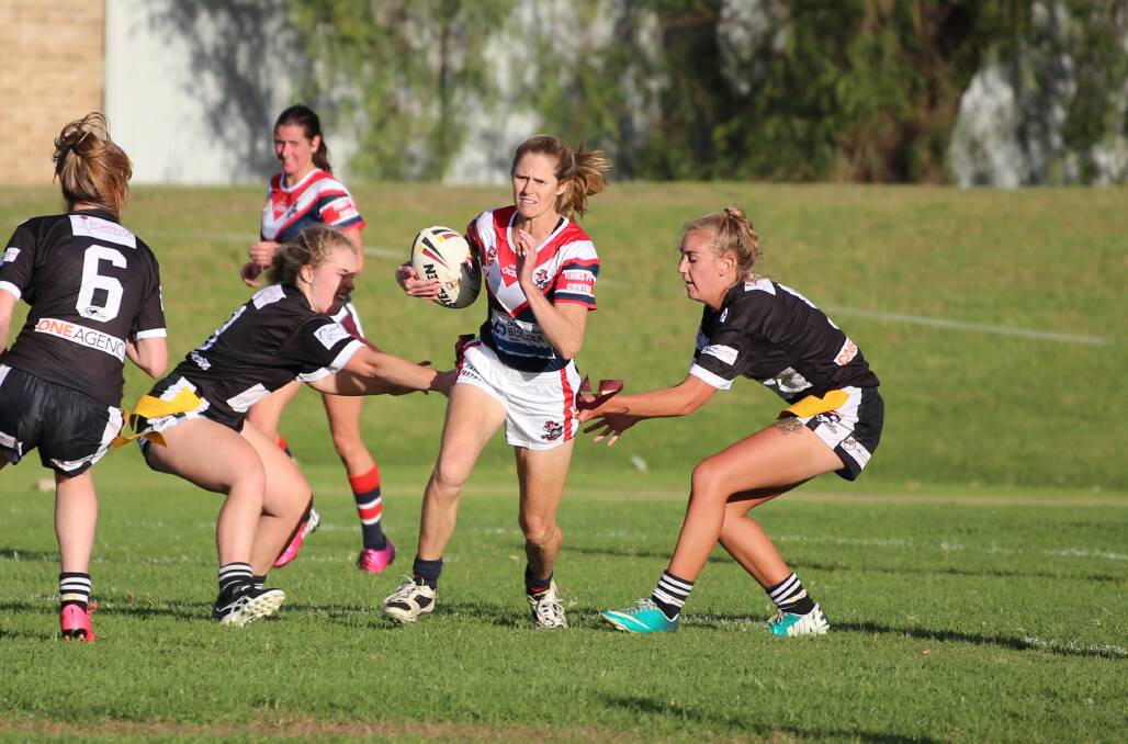 Holding out: A Bega Chick gets attacked from both sides in Bega's 14-12 win over the Cooma Fillies last weekend. 