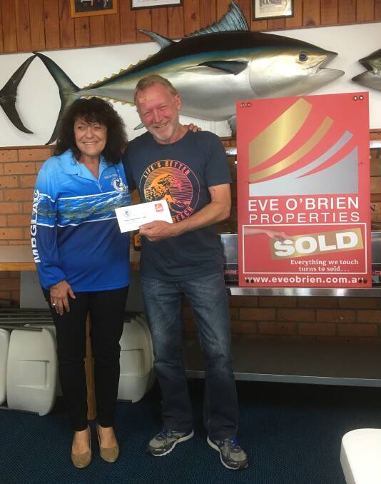 Competition winner: Eve O'Brien passes over the prize to Brian Davey of Tura Beach. Brian's giant 94.2cm dusky flathead was caught and released at Mogareeka. 