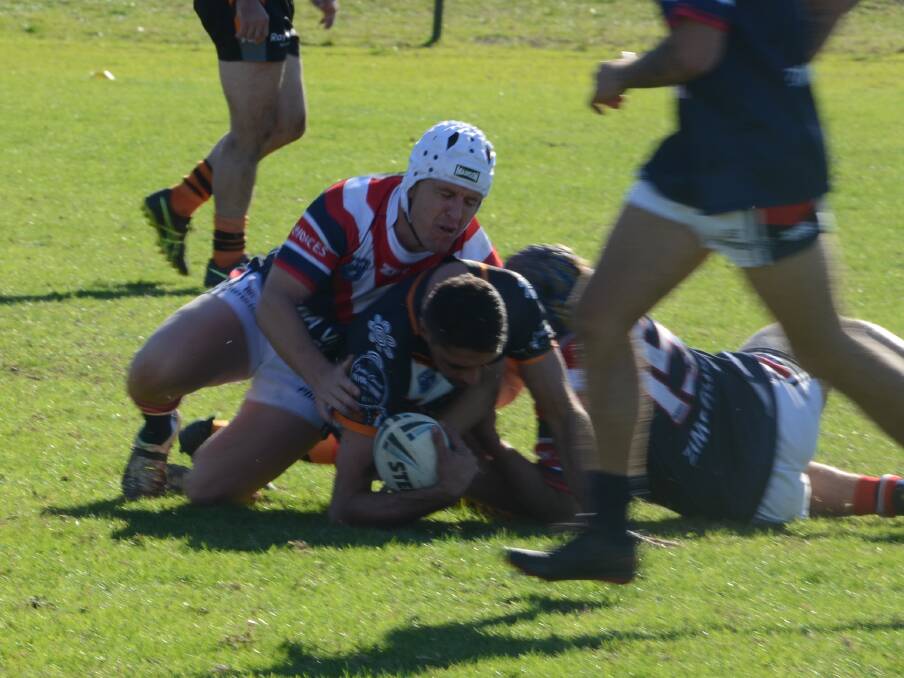 Tackle: Roosters coach Scott Barton helps lay down a tackle during the club's loss to the Bay Tigers at McKay Park on Sunday. Picture: Joel Erickson. 