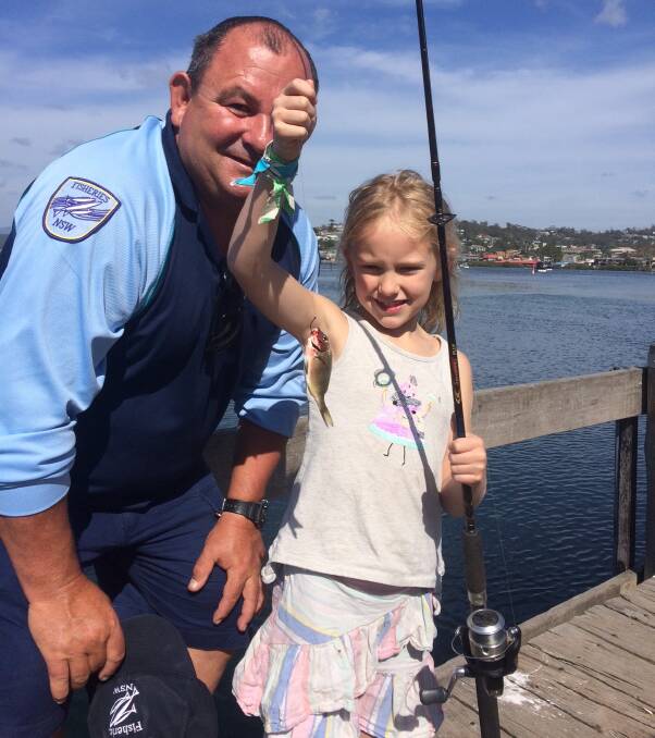 Look what I caught!: Matt Proctor from DPI Eden assists six-year-old Rachel Croxford of Candelo with her first ever snapper at the DPI's family fishing day last Saturday at Spencer Park.